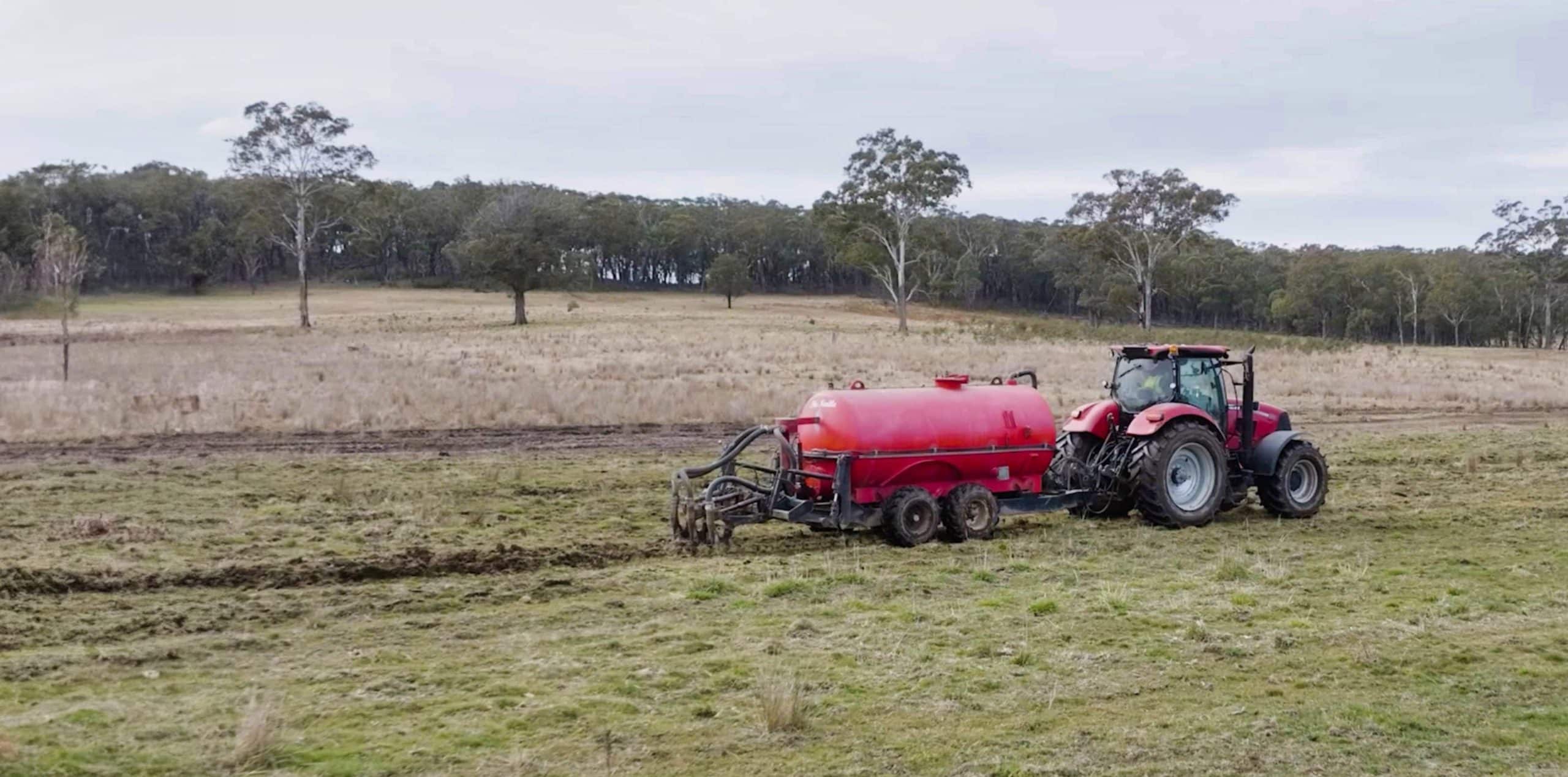 Tractor spreading liquid fertiliser on a field