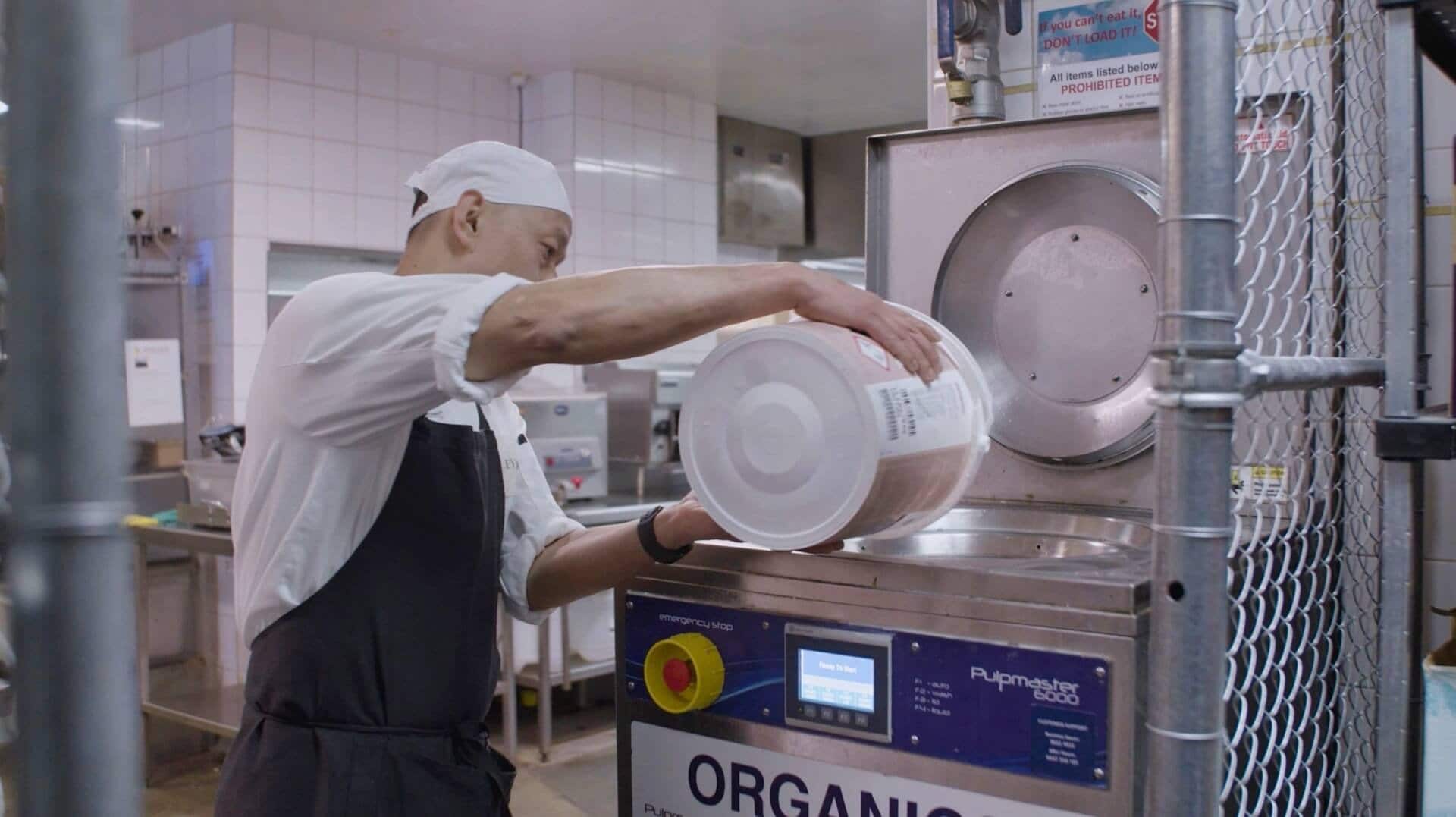 Chef loading food scraps into a Pulpmaster caddy